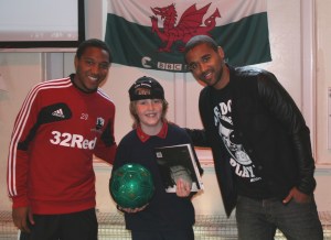 Daniel Russell recieves his autographed football from Luke and Jonathan